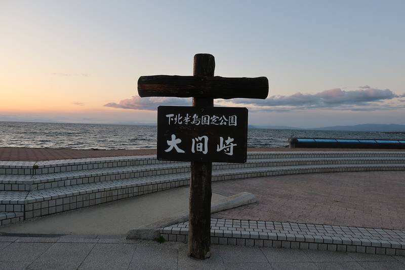 夕暮れの大間崎、「大間崎」の木の標柱と津軽海峡
